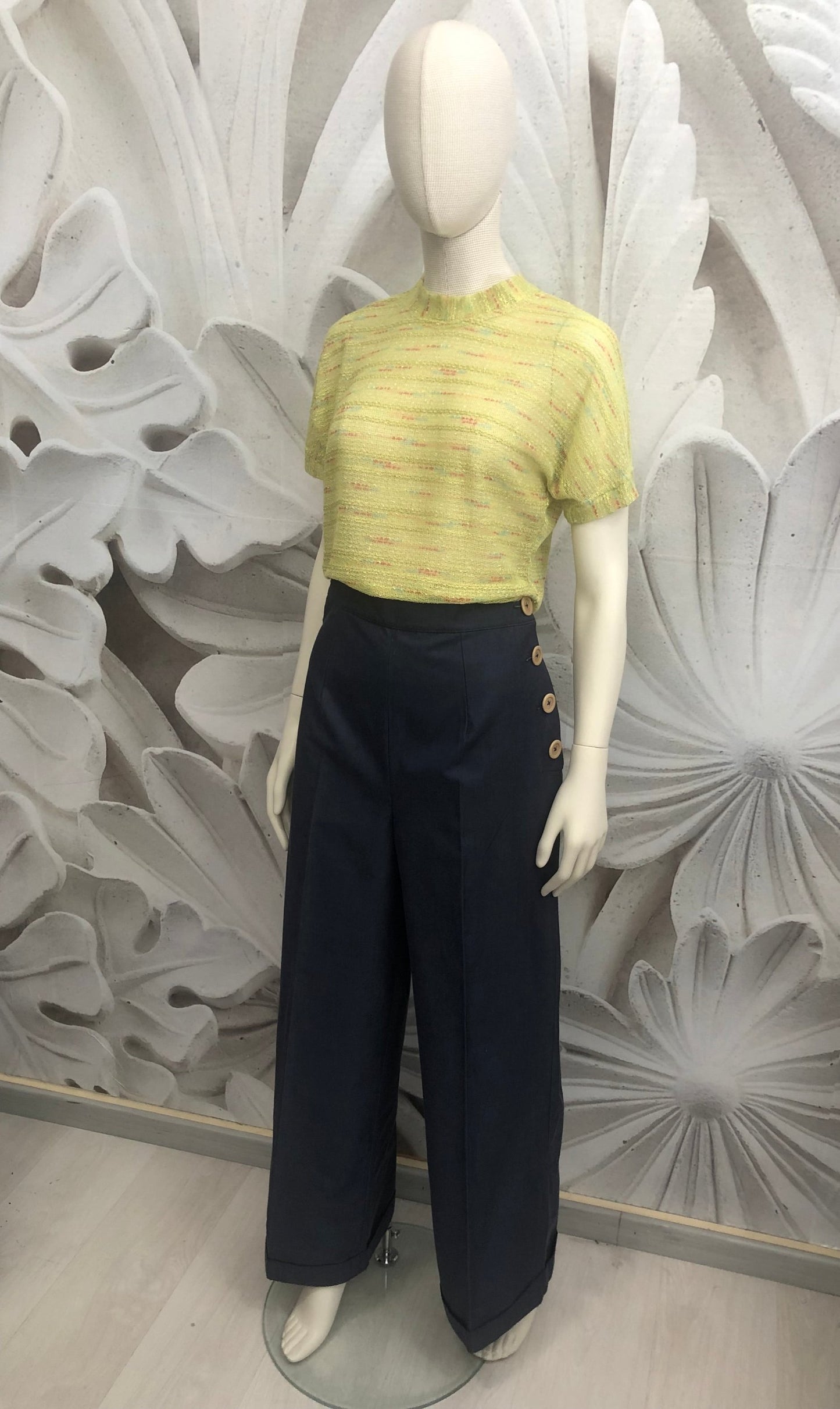 pantalone vita alta in gabardine blu allacciati con bottoni laterali beige. t-shirt in maglia di cotone verde