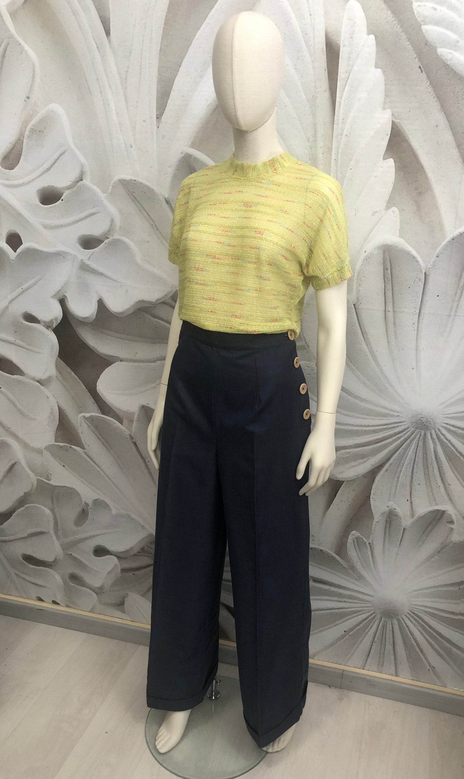 pantalone vita alta in gabardine blu allacciati con bottoni laterali beige. t-shirt in maglia di cotone verde