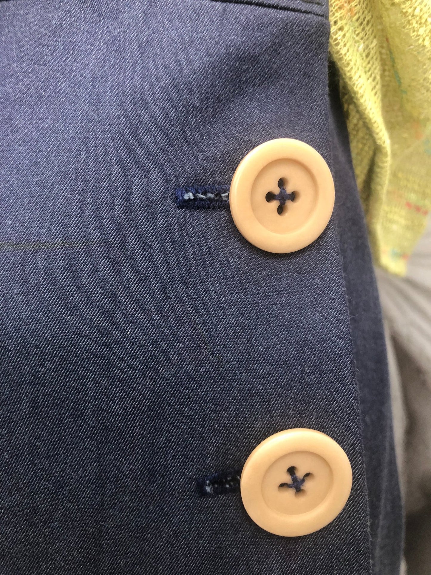 pantalone vita alta in gabardine blu allacciati con bottoni laterali beige. t-shirt in maglia di cotone verde