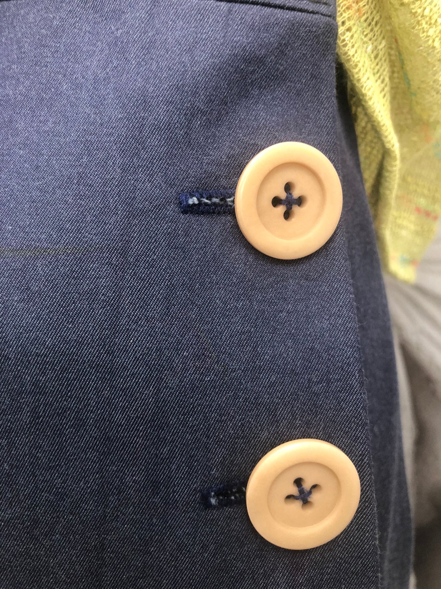 pantalone vita alta in gabardine blu allacciati con bottoni laterali beige. t-shirt in maglia di cotone verde