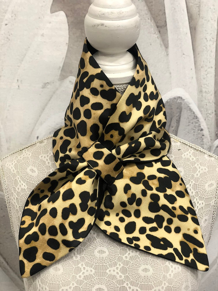 Sciarpina Marlene ispirata ad un teglio anni 40, realizzata in tessuto animalier misto cotone/seta da un lato e rasone nero misto cotone  dell'altro.  Asola cucita a mano.  Lunghezza 80 cm