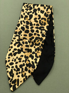 Sciarpina Marlene ispirata ad un teglio anni 40, realizzata in tessuto animalier misto cotone/seta da un lato e rasone nero misto cotone dell'altro. Asola cucita a mano. Lunghezza 80 cm